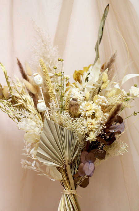 Autumn Moonrise dried flower bouquet of mixed pale flowers against light peach background 