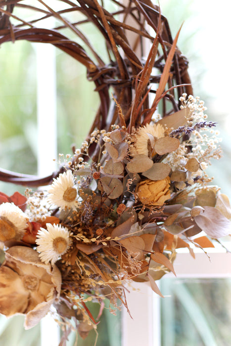 Close up of dried flower wreath with natural coloured helichrysum and dried green eucalyptus